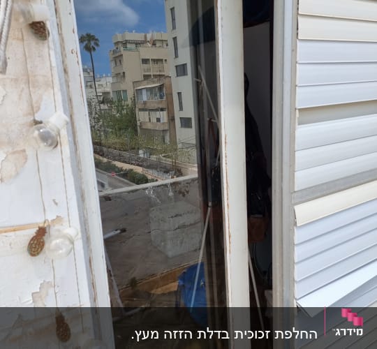 דלת זכוכית עם השתקפות בניינים ושמים